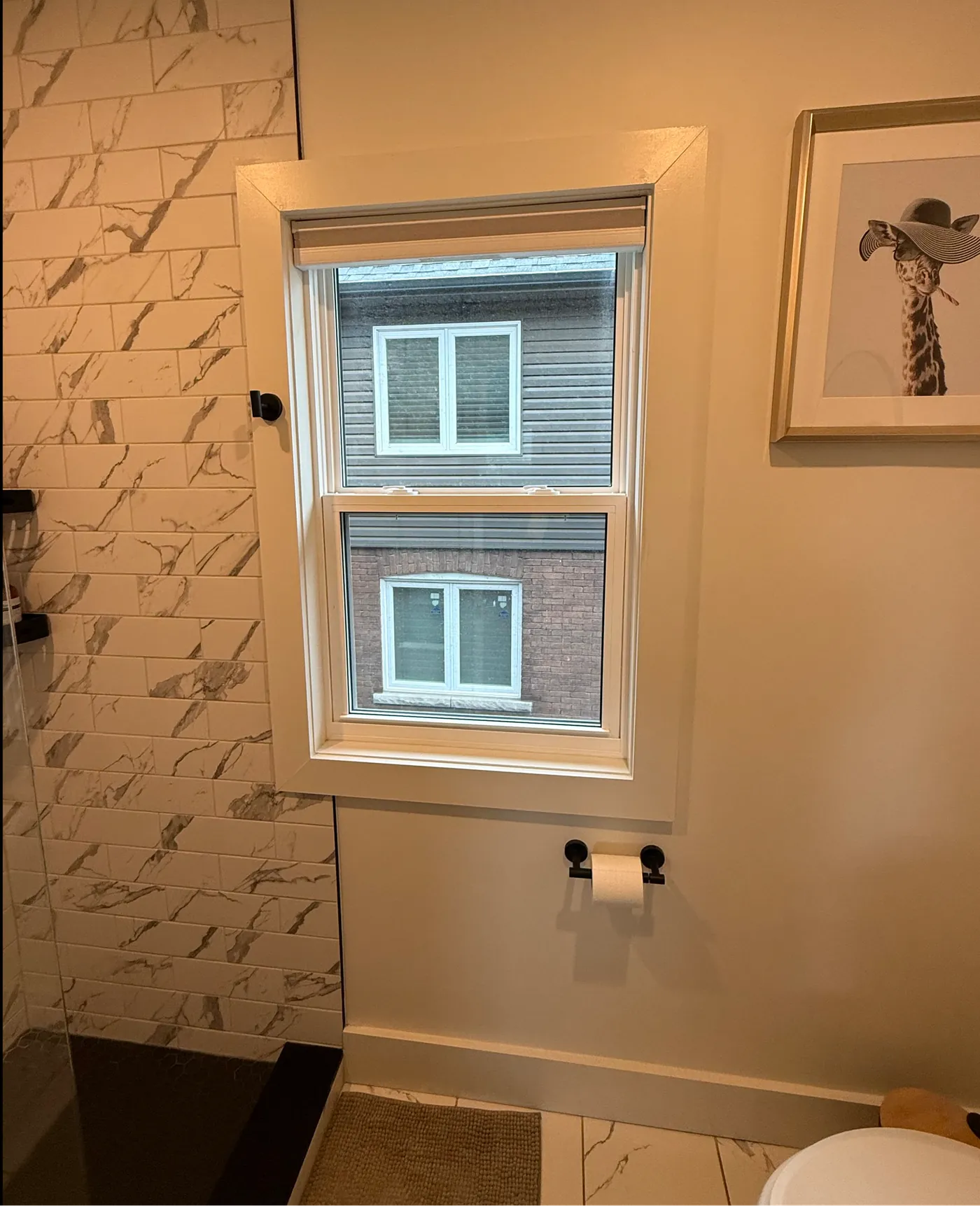 The same bathroom window before film: clear glass with a full view straight through to the homes outside, and no daytime privacy.